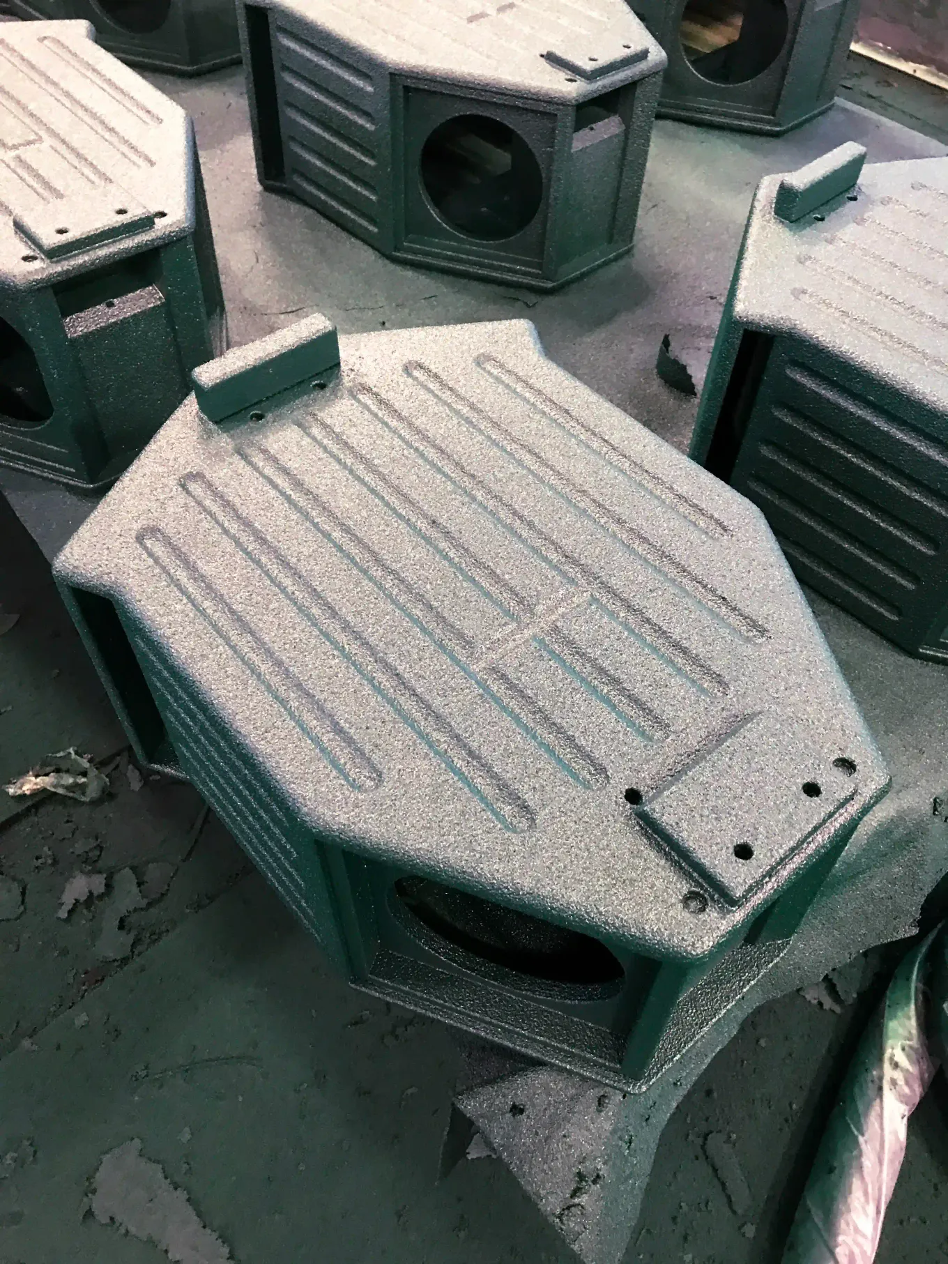 Industrial equipment housings coated in speckled protective coating on the shop floor